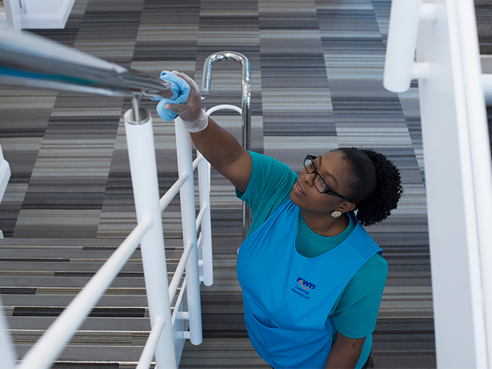 Member of KWB Corporate Cleaning's team providing cleaning services in an office or school stairwell